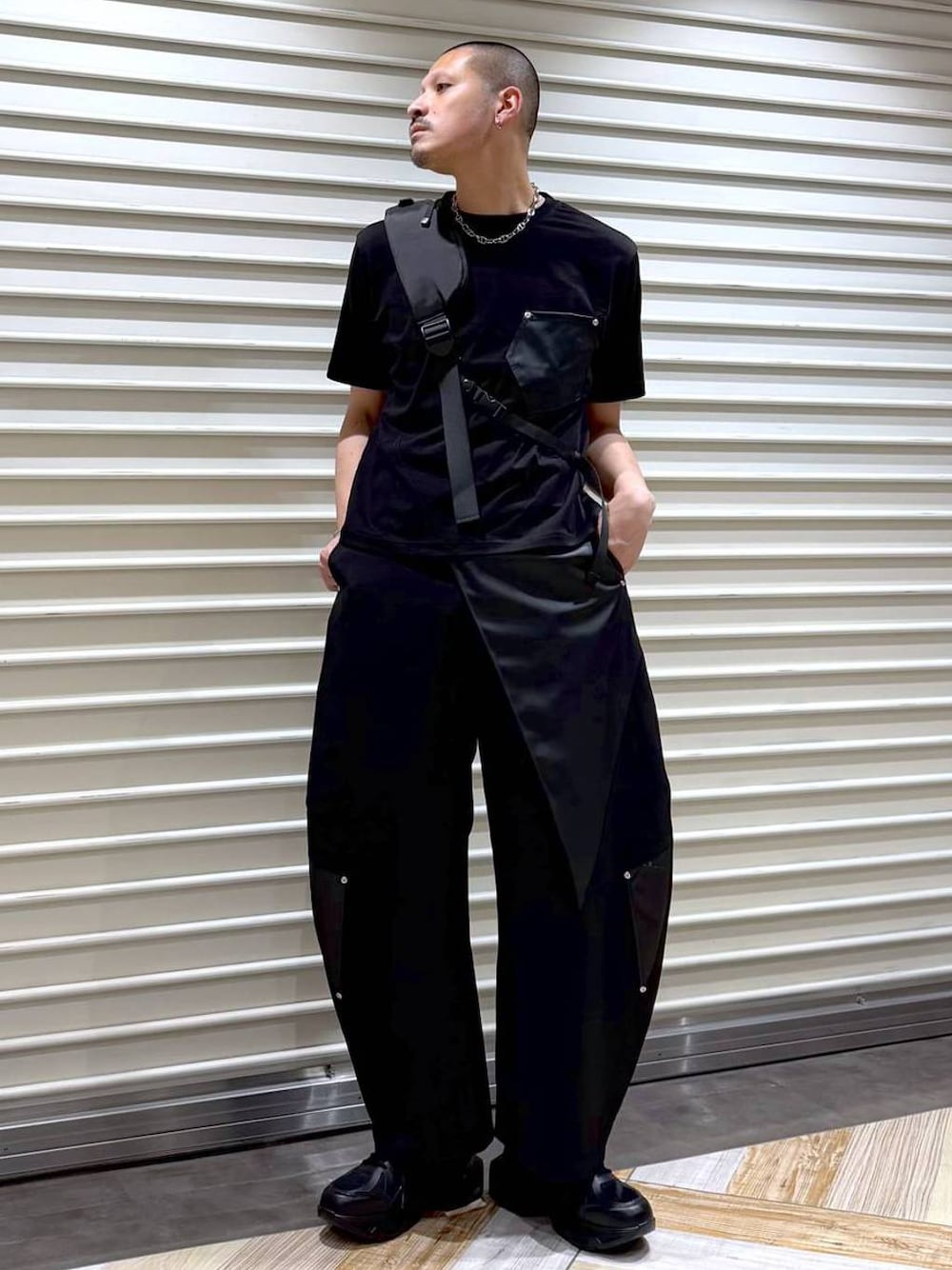 ブラック系のスラックス、ブラック系のTシャツ/カットソー、ブラック系のスニーカーを着用したメンズの夏コーディネートの1枚目の写真