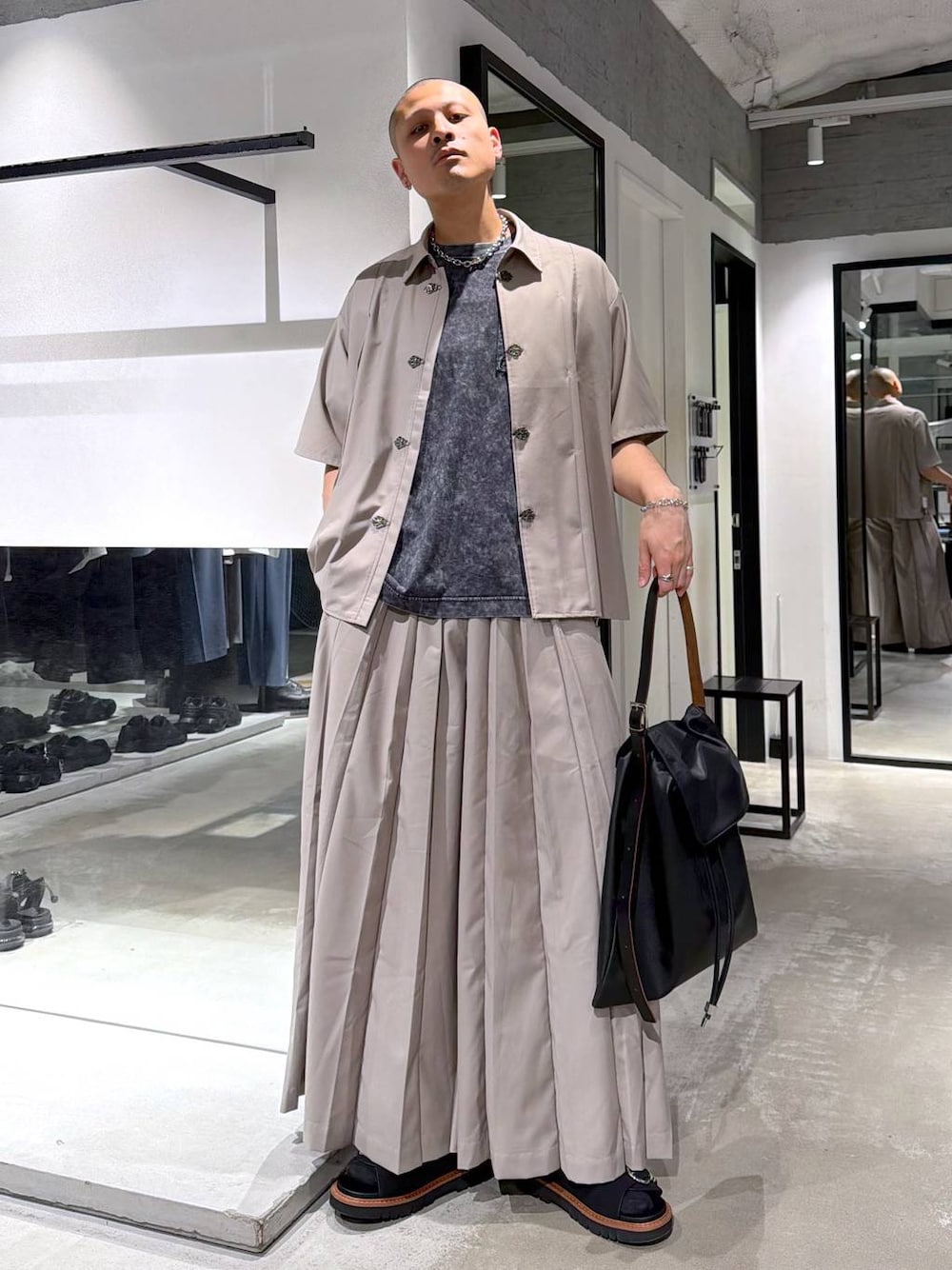 グレー系のTシャツ/カットソー、ブラウン系のサンダル、ブラック系のトートバッグを着用したメンズの春コーディネートの1枚目の写真