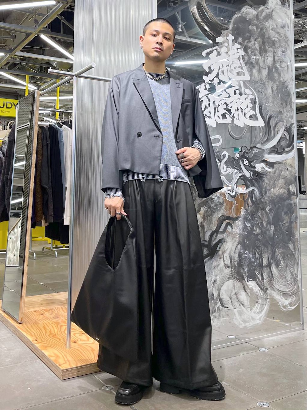 ブラック系のトートバッグ、ブラック系のドレスシューズ、グレー系のテーラードジャケットを着用したメンズの秋コーディネートの1枚目の写真