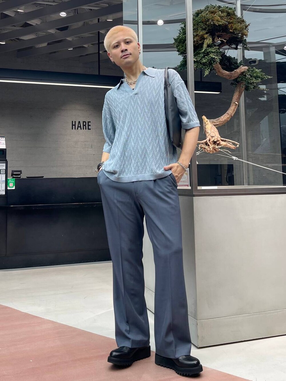 ブラック系のドレスシューズ、ブラック系のトートバッグ、ブルー系のポロシャツを着用したメンズの夏コーディネートの1枚目の写真