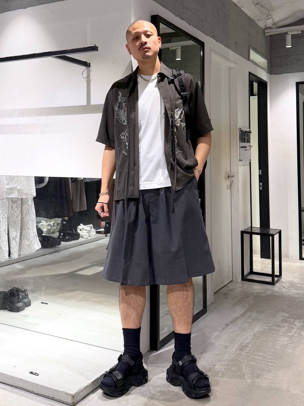 ブラック系のサンダル、ホワイト系のTシャツ/カットソー、ブラック系のバックパック/リュックを着用したメンズの夏コーディネートの1枚目の写真