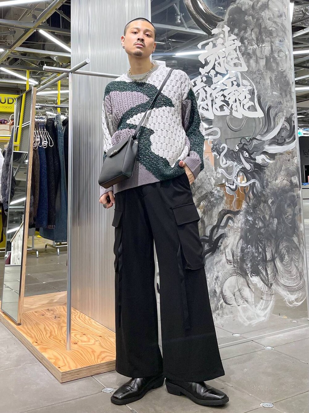 ブラック系のブーツ、ブラック系のカーゴパンツ、グレー系のショルダーバッグを着用したメンズの秋コーディネートの1枚目の写真
