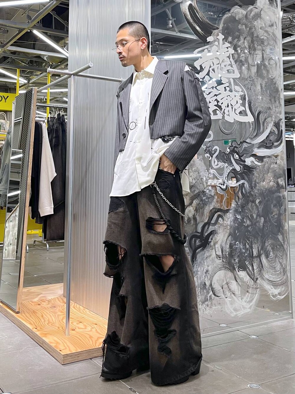 ブラック系のデニムパンツ、ブラック系のドレスシューズ、グレー系のテーラードジャケットを着用したメンズの夏コーディネートの1枚目の写真