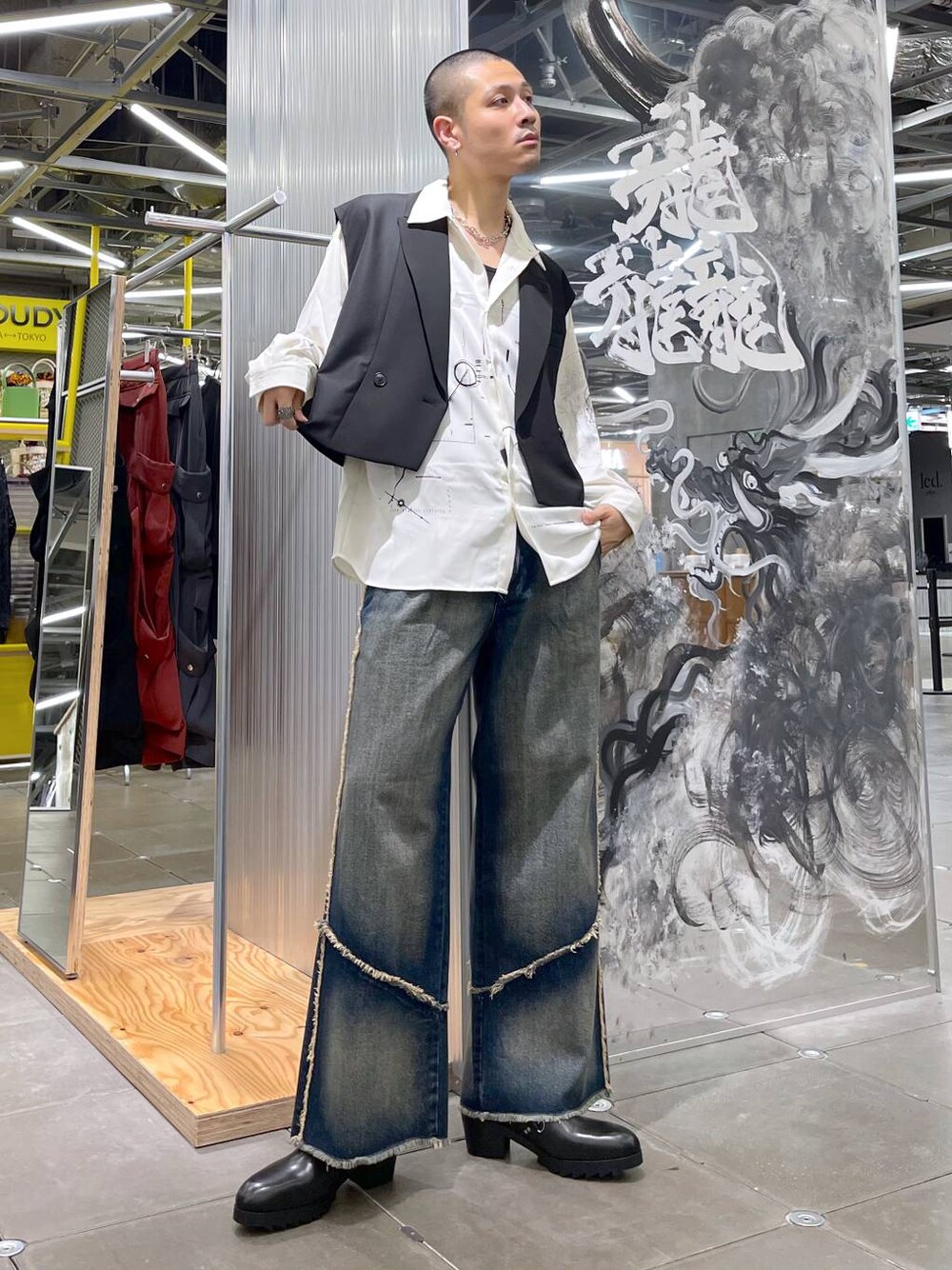 ブルー系のデニムパンツ、ブラック系のベスト、ブラック系のドレスシューズを着用したメンズの夏コーディネートの1枚目の写真