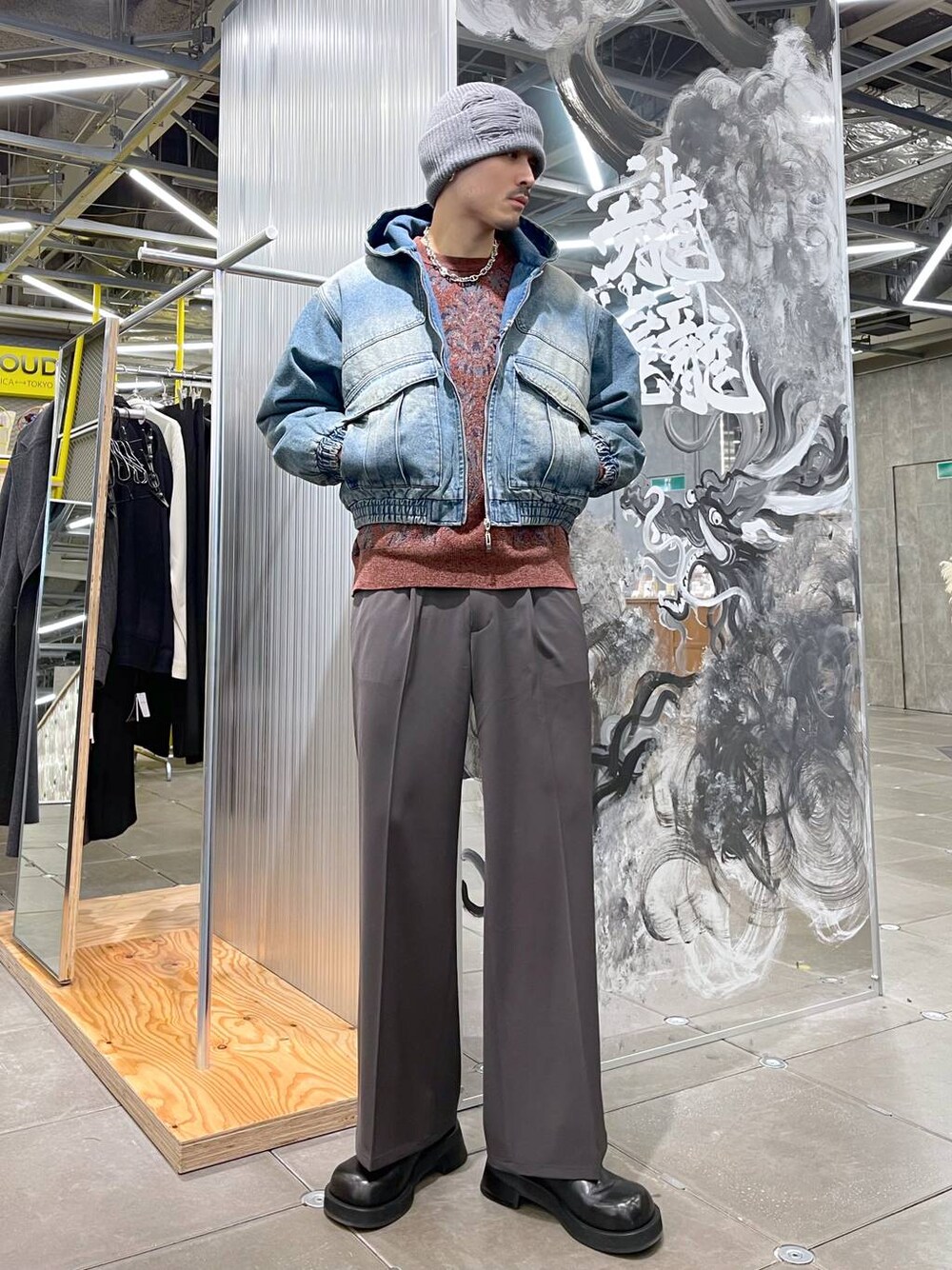 レッド系のニット/セーター、ブラウン系のスラックス、ブラック系のドレスシューズを着用したメンズの冬コーディネートの1枚目の写真
