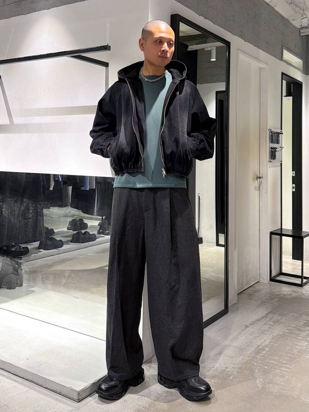 ブラック系のスニーカー、ブラック系のブルゾン、ブラック系のスラックスを着用したメンズの春コーディネートの1枚目の写真