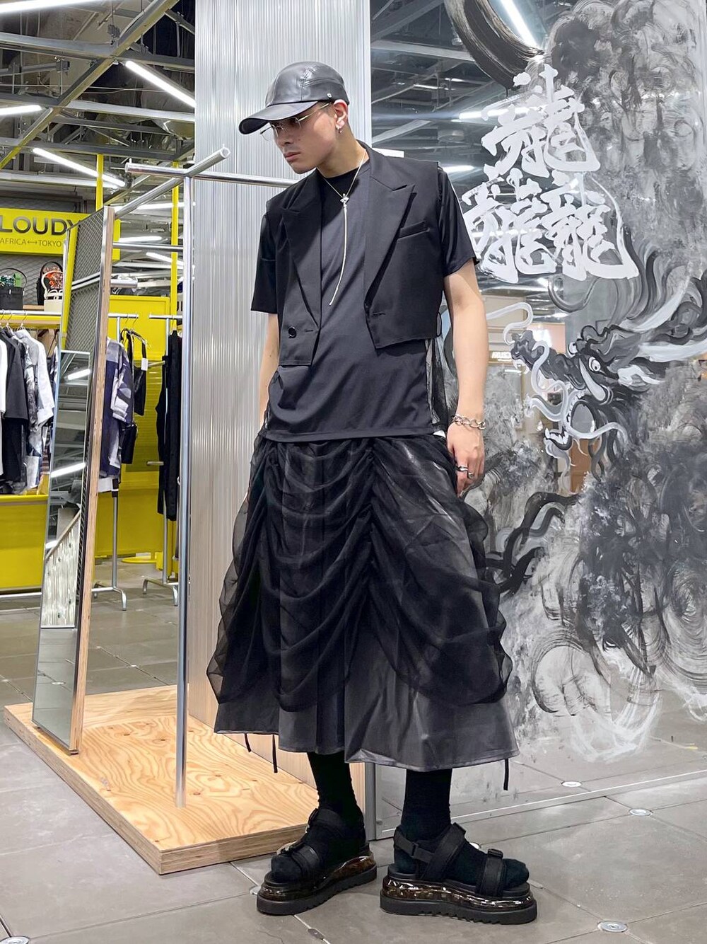 ブラック系のTシャツ/カットソー、ブラック系のサンダル、ブラック系のテーラードジャケットを着用したメンズの夏コーディネートの1枚目の写真