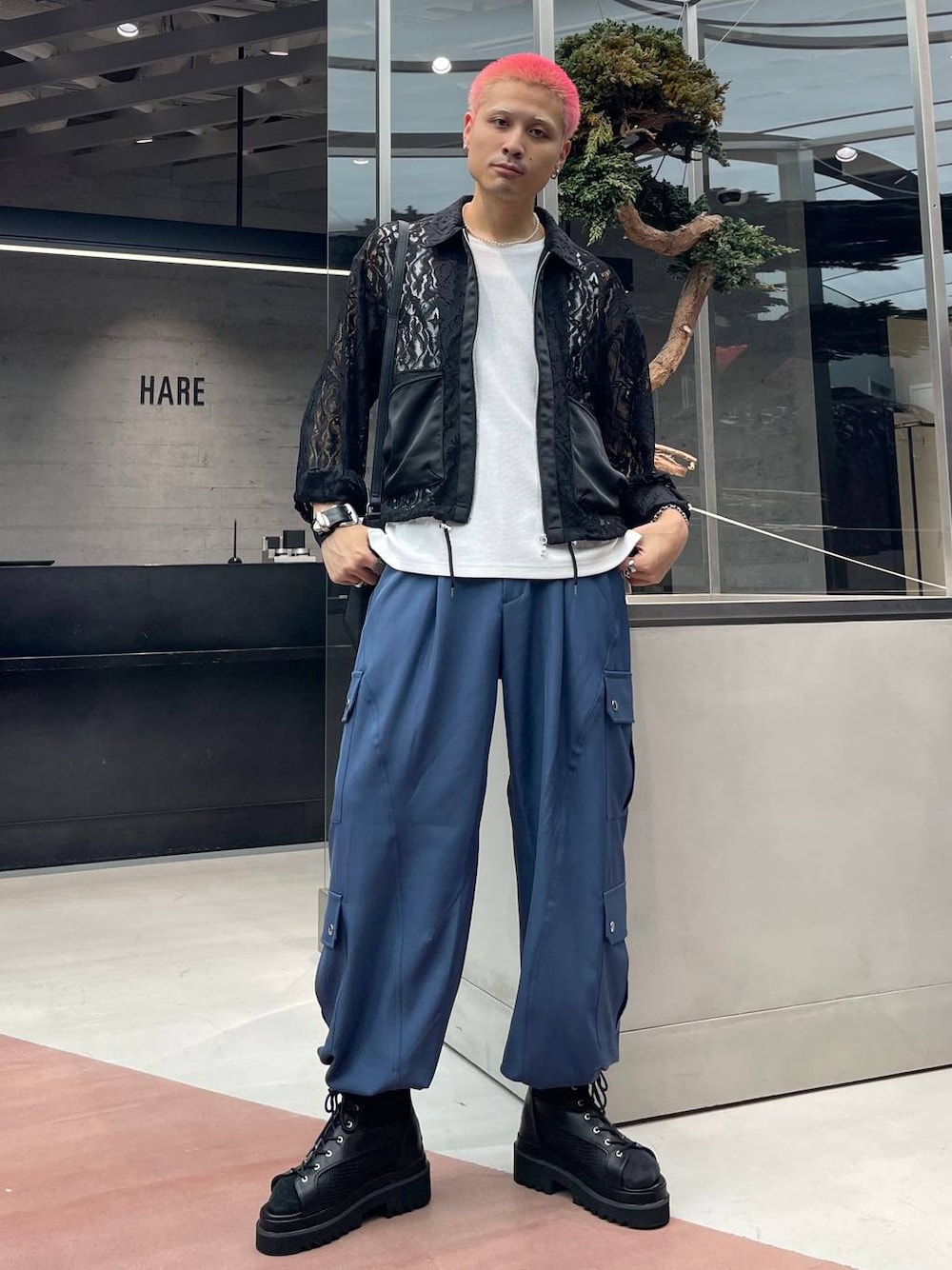 ブラック系のブルゾン、ブルー系のカーゴパンツ、ホワイト系のネックレスを着用したメンズの秋コーディネートの1枚目の写真