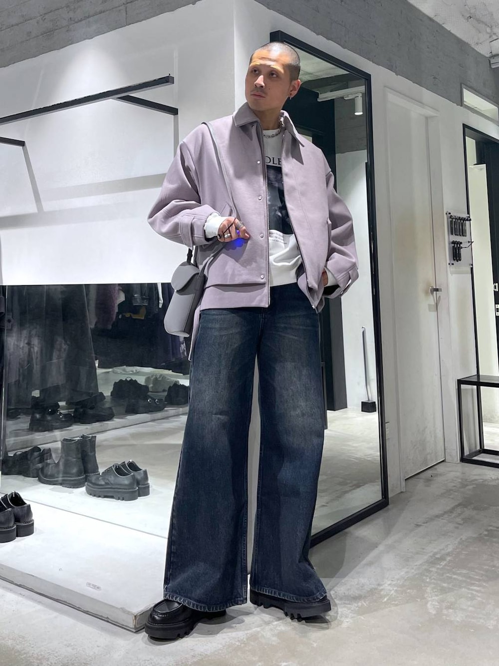 パープル系のブルゾン、ブルー系のデニムパンツ、ブラック系のドレスシューズを着用したメンズの秋コーディネートの1枚目の写真