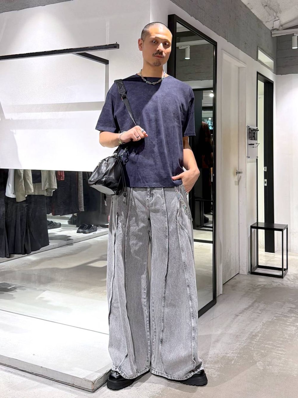 ブラック系のショルダーバッグ、ブラック系のローファー、グレー系のデニムパンツを着用したメンズの夏コーディネートの1枚目の写真