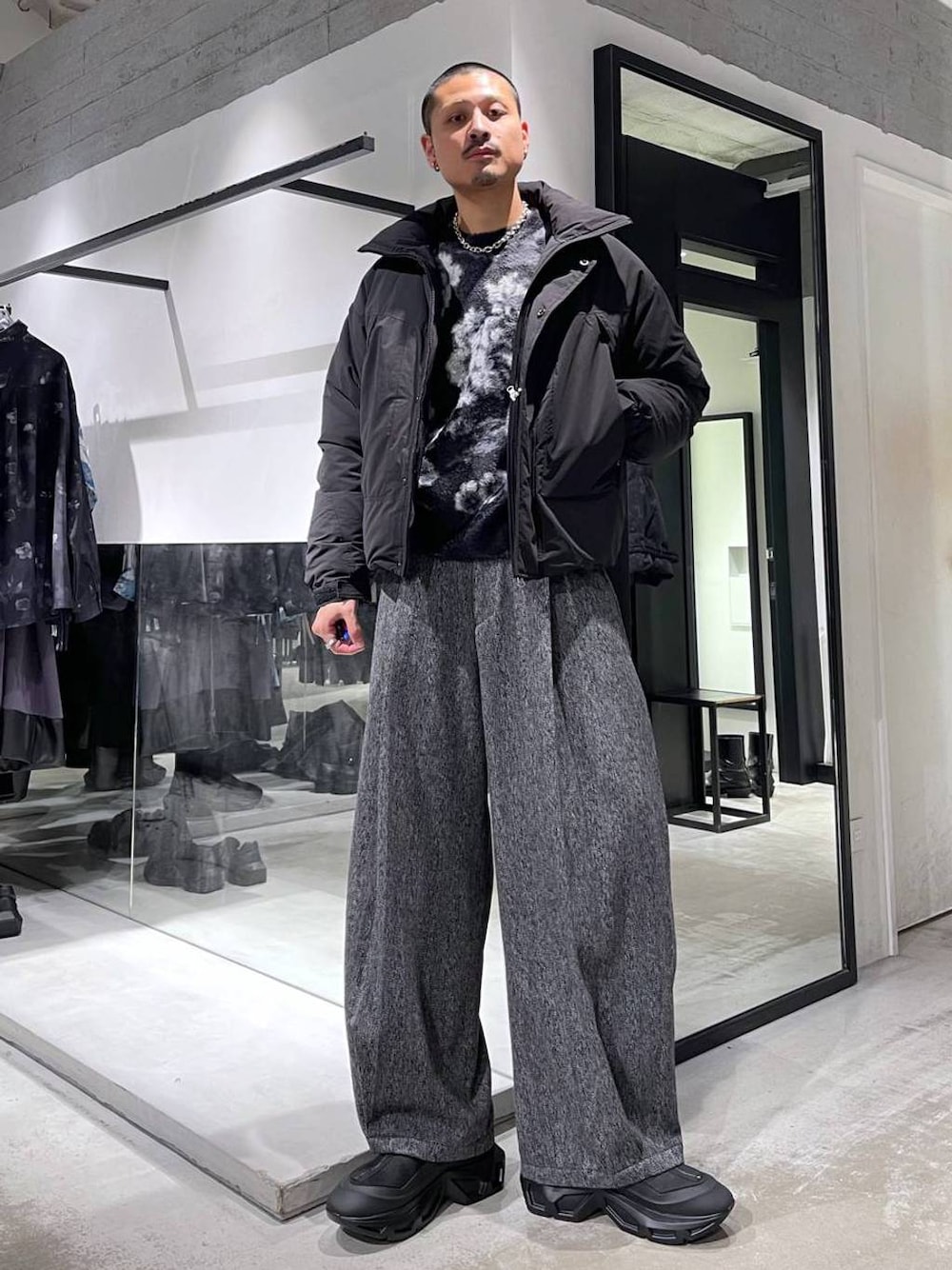 ブラック系のニット/セーター、ブラック系のダウンジャケット/コート、ブラック系のスラックスを着用したメンズの冬コーディネートの1枚目の写真