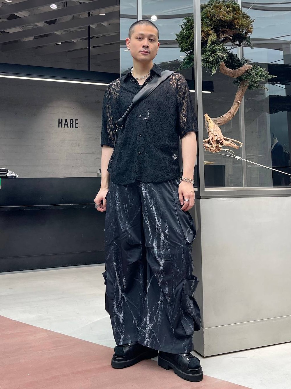 ブラック系のサンダル、ブラック系のカーゴパンツ、ブラック系のショルダーバッグを着用したメンズの夏コーディネートの1枚目の写真