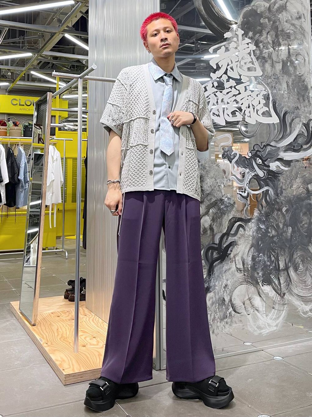 パープル系のスラックス、ブラック系のサンダル、グレー系のカーディガン/ボレロを着用したメンズの夏コーディネートの1枚目の写真