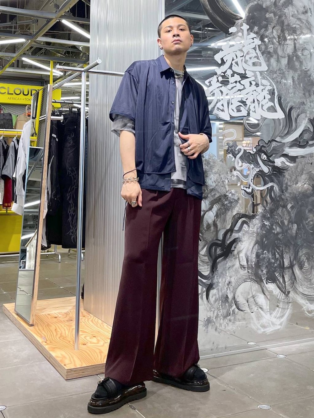 レッド系のスラックス、ブラック系のサンダル、ブルー系のシャツ/ブラウスを着用したメンズの夏コーディネートの1枚目の写真