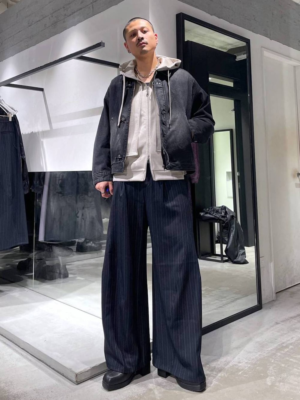 ブルー系のスラックス、ブラック系のブーツ、シルバー系のネックレスを着用したメンズの冬コーディネートの1枚目の写真