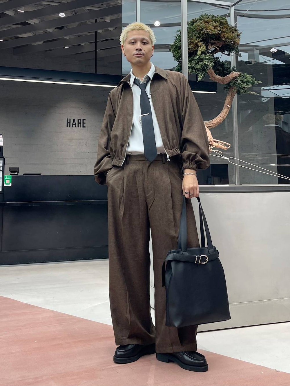 ブラック系のネクタイ、ブラウン系のスラックス、ブラック系のトートバッグを着用したメンズの秋コーディネートの1枚目の写真