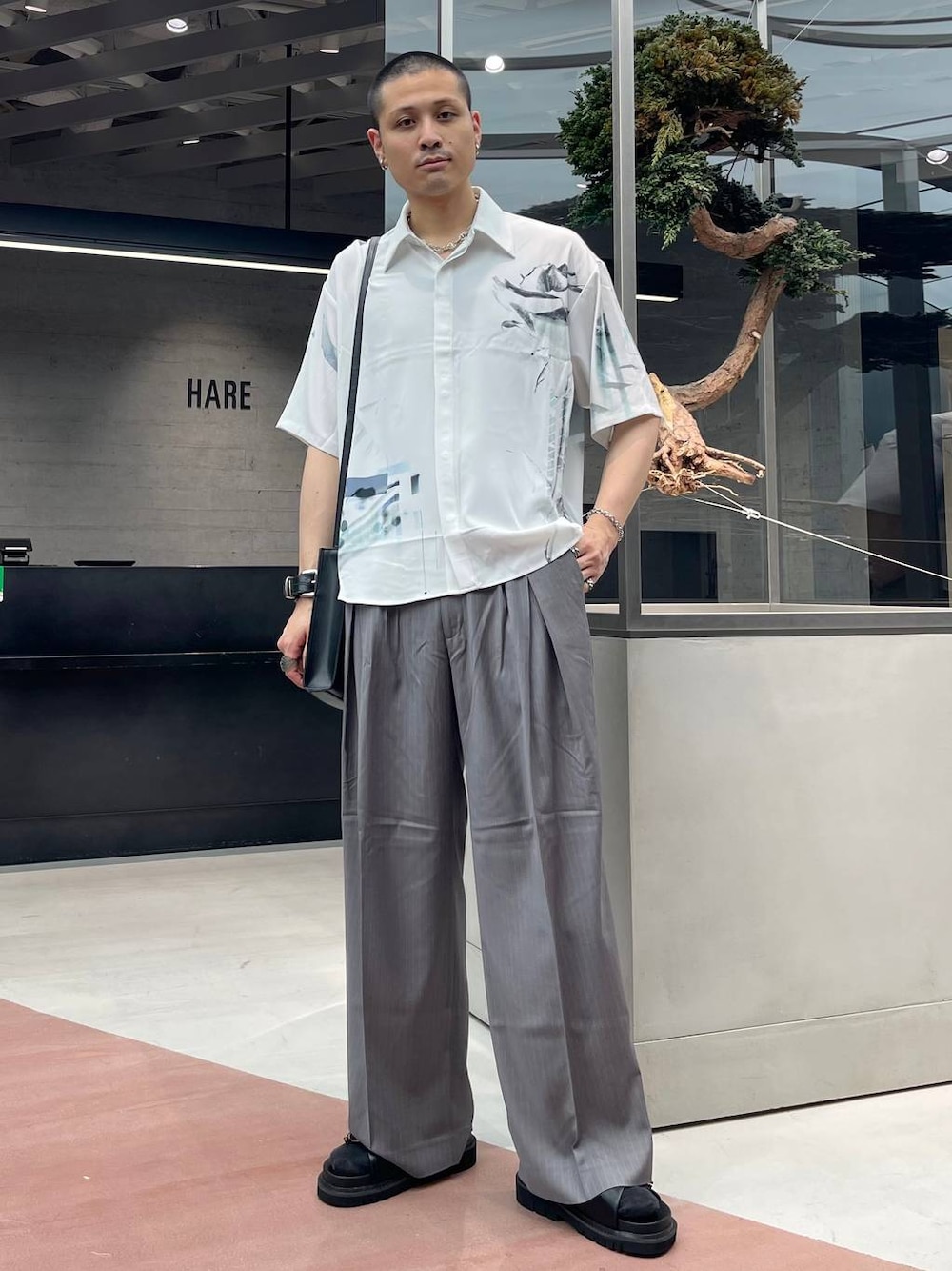 ブラック系のショルダーバッグ、ブラック系のサンダル、ホワイト系のシャツ/ブラウスを着用したメンズの夏コーディネートの1枚目の写真