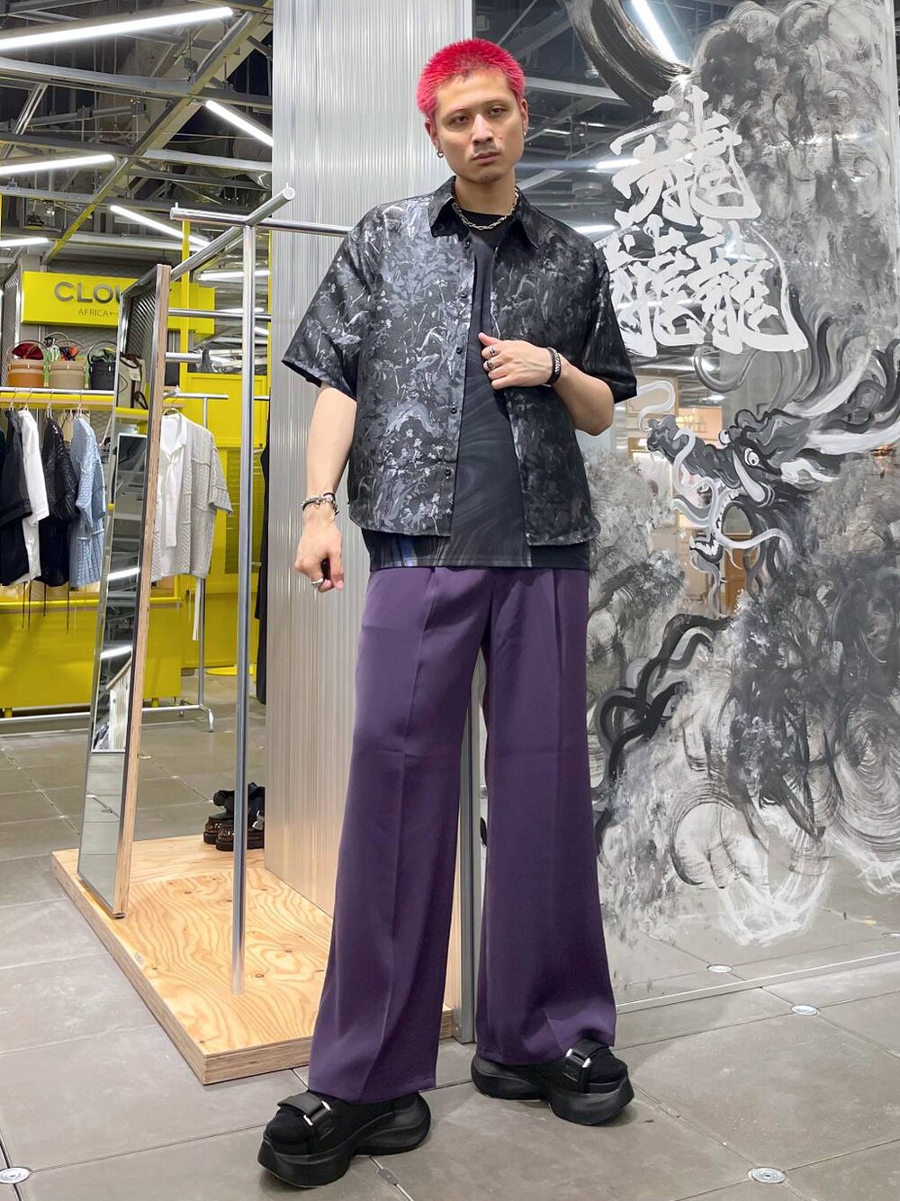 パープル系のスラックス、ブラック系のサンダル、ブラック系のTシャツ/カットソーを着用したメンズの夏コーディネートの1枚目の写真