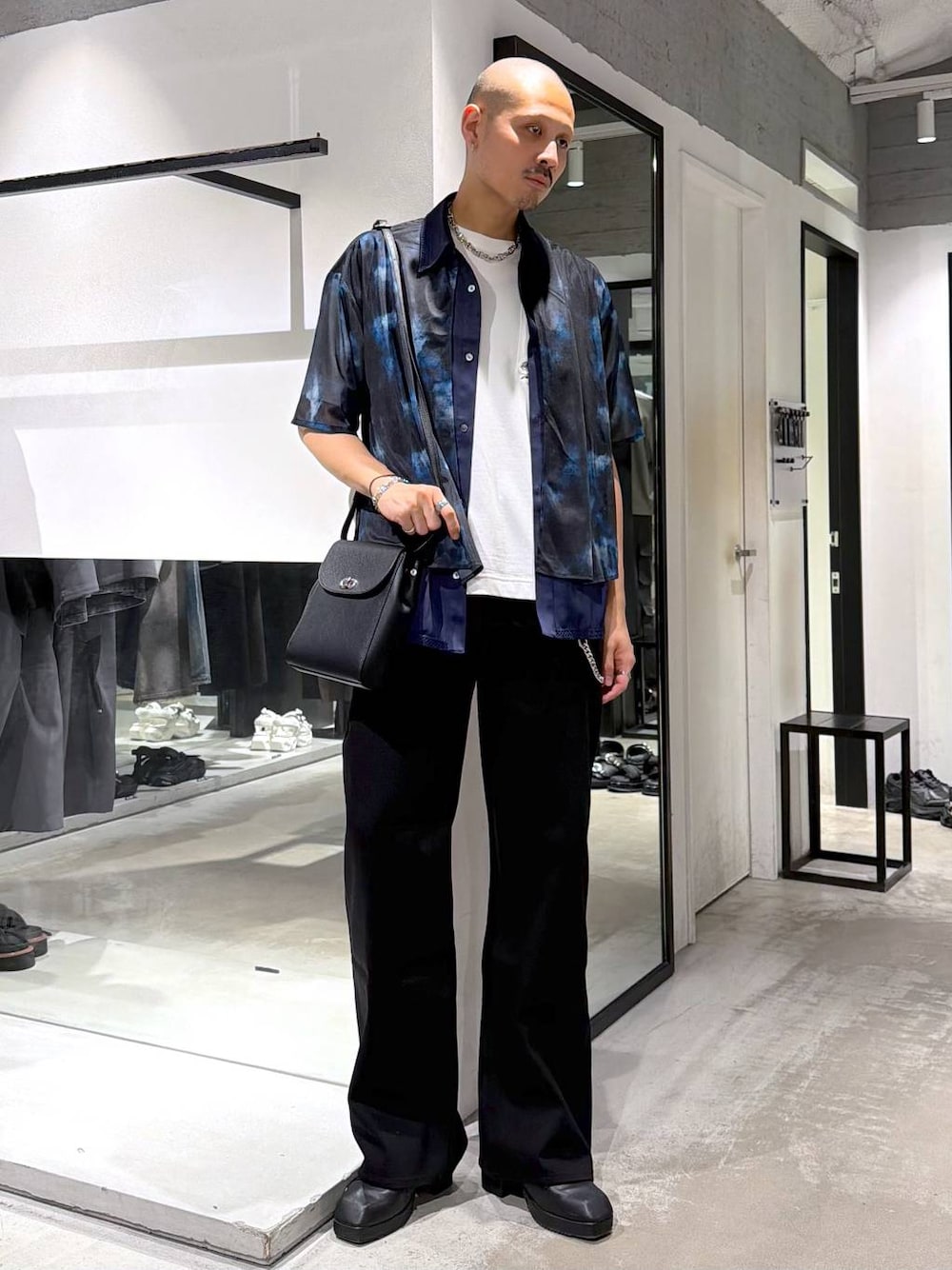 ブラック系のショルダーバッグ、ホワイト系のTシャツ/カットソー、ブラック系のサンダルを着用したメンズの夏コーディネートの1枚目の写真