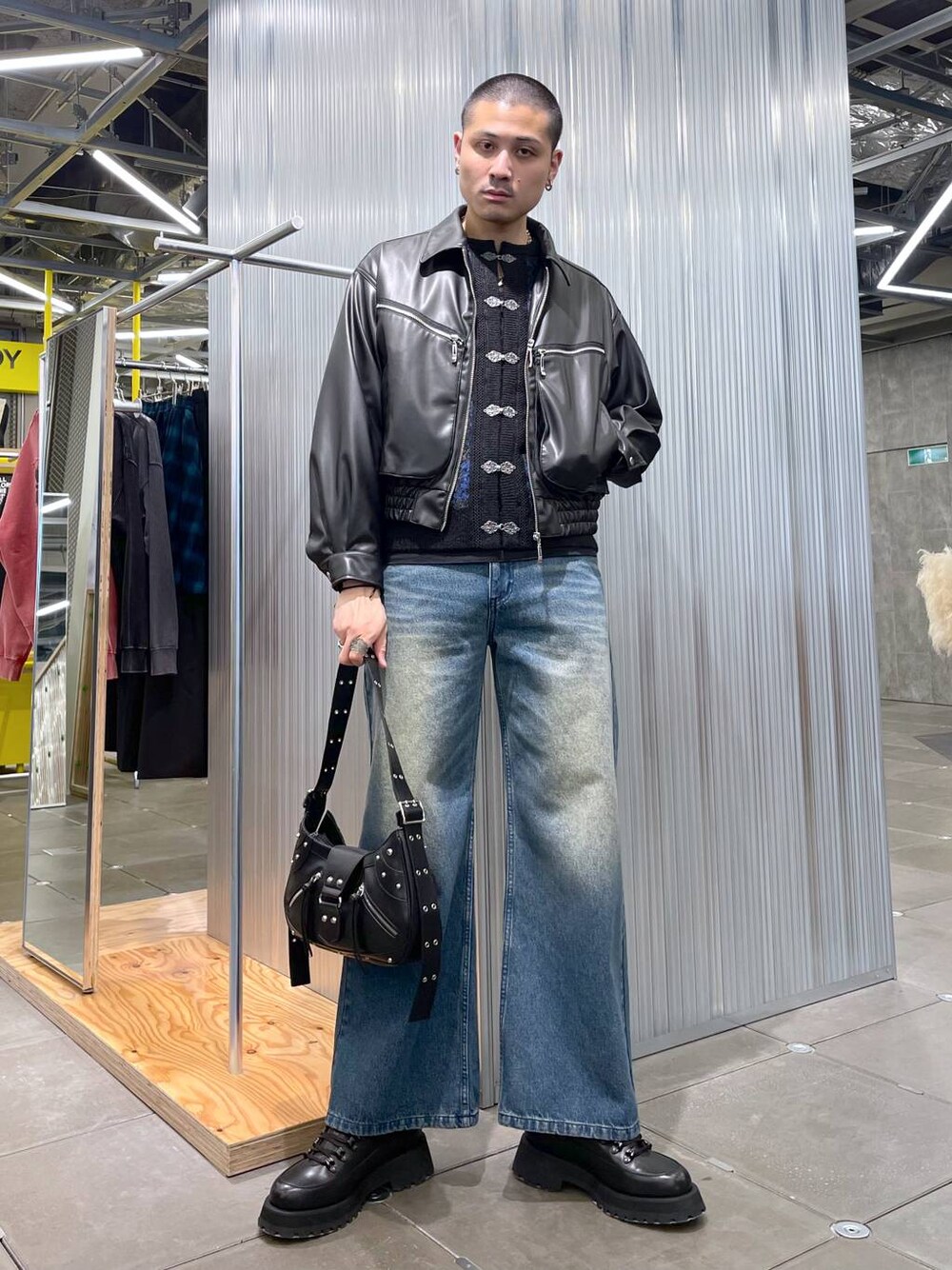 ブルー系のデニムパンツ、ブラック系のドレスシューズ、ブラック系のショルダーバッグを着用したメンズの春コーディネートの1枚目の写真