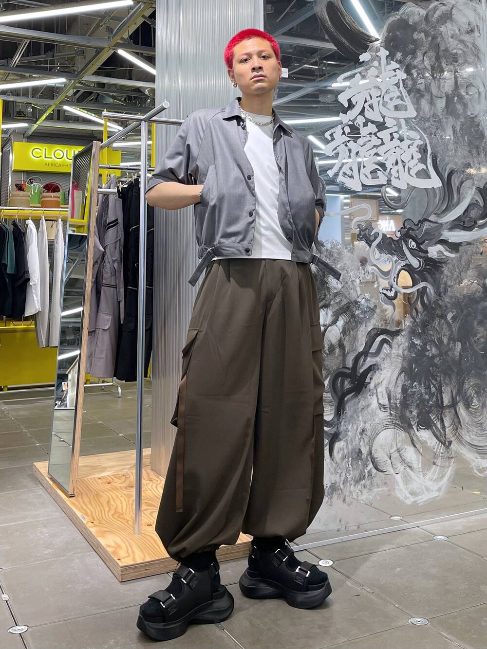 ブラック系のサンダル、ホワイト系のTシャツ/カットソー、ブラウン系のカーゴパンツを着用したメンズの春コーディネートの1枚目の写真