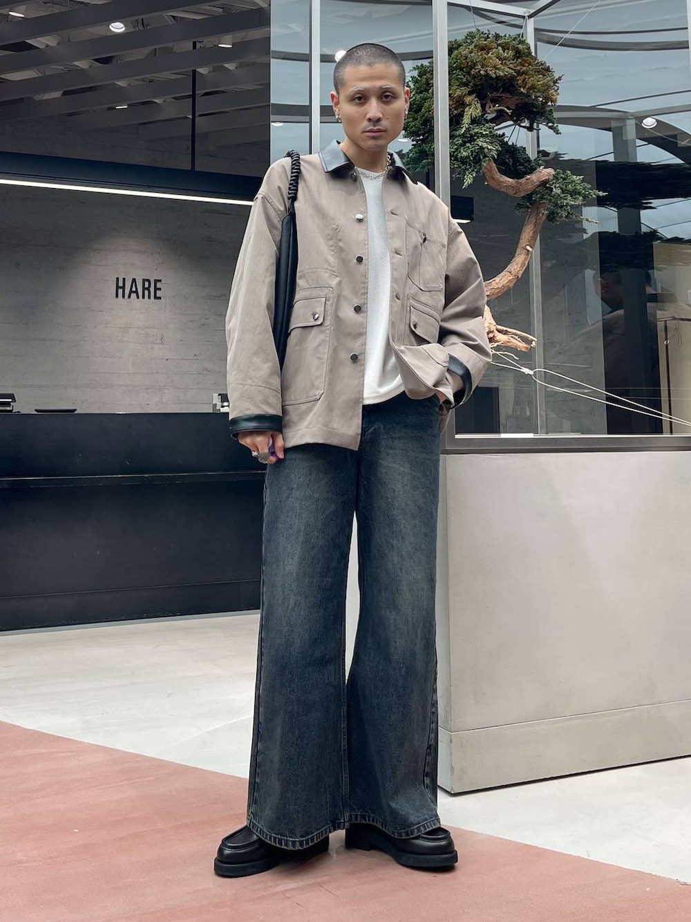 ホワイト系のTシャツ/カットソー、ブラック系のローファー、ブルー系のデニムパンツを着用したメンズの秋コーディネートの1枚目の写真