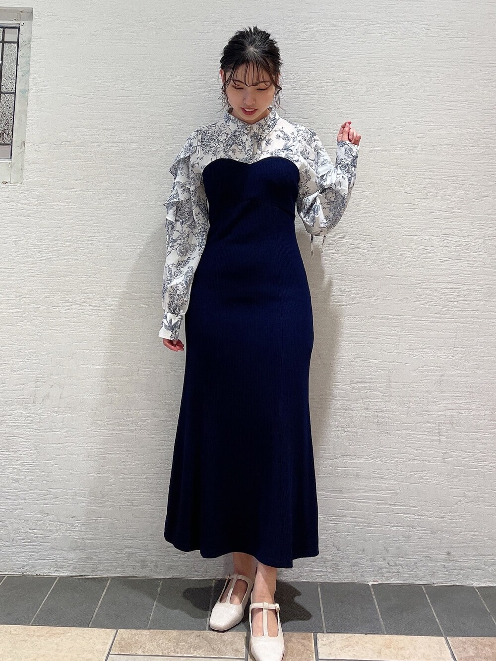 ブルー系のワンピース、ホワイト系のパンプスを着用したレディースの冬コーディネートの1枚目の写真