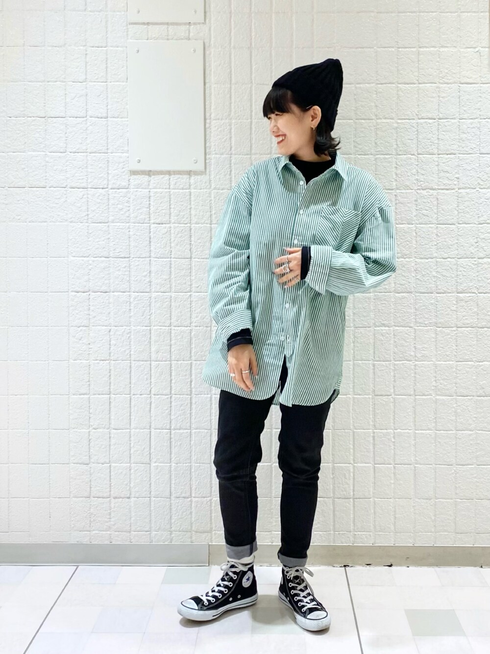 グリーン系のシャツ/ブラウス、ブラック系のTシャツ/カットソー、ブラック系のデニムパンツを着用したレディースの冬コーディネートの1枚目の写真