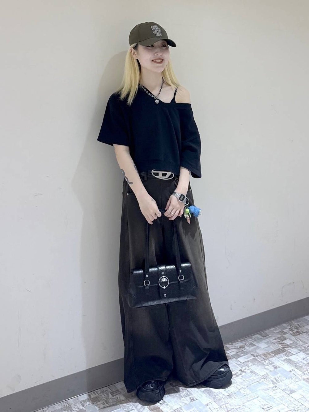 ブラウン系のデニムパンツ、ブラック系のスウェット、ブラック系のブーツを着用したレディースの夏コーディネートの1枚目の写真