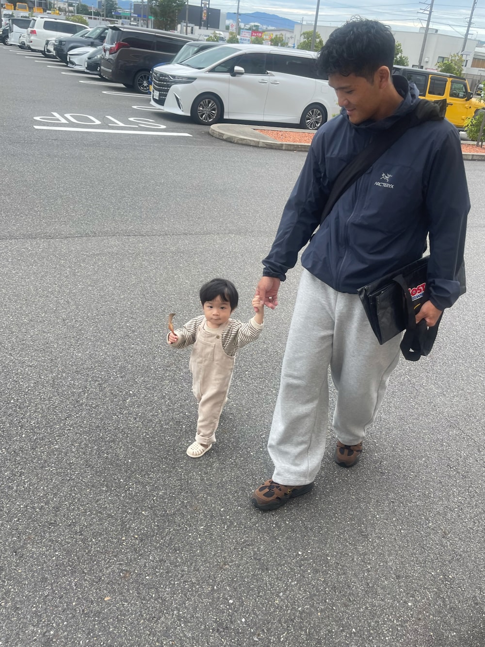 グレー系のスウェットパンツ、ブラウン系のスニーカー、ブルー系のブルゾンを着用したメンズの秋コーディネートの1枚目の写真