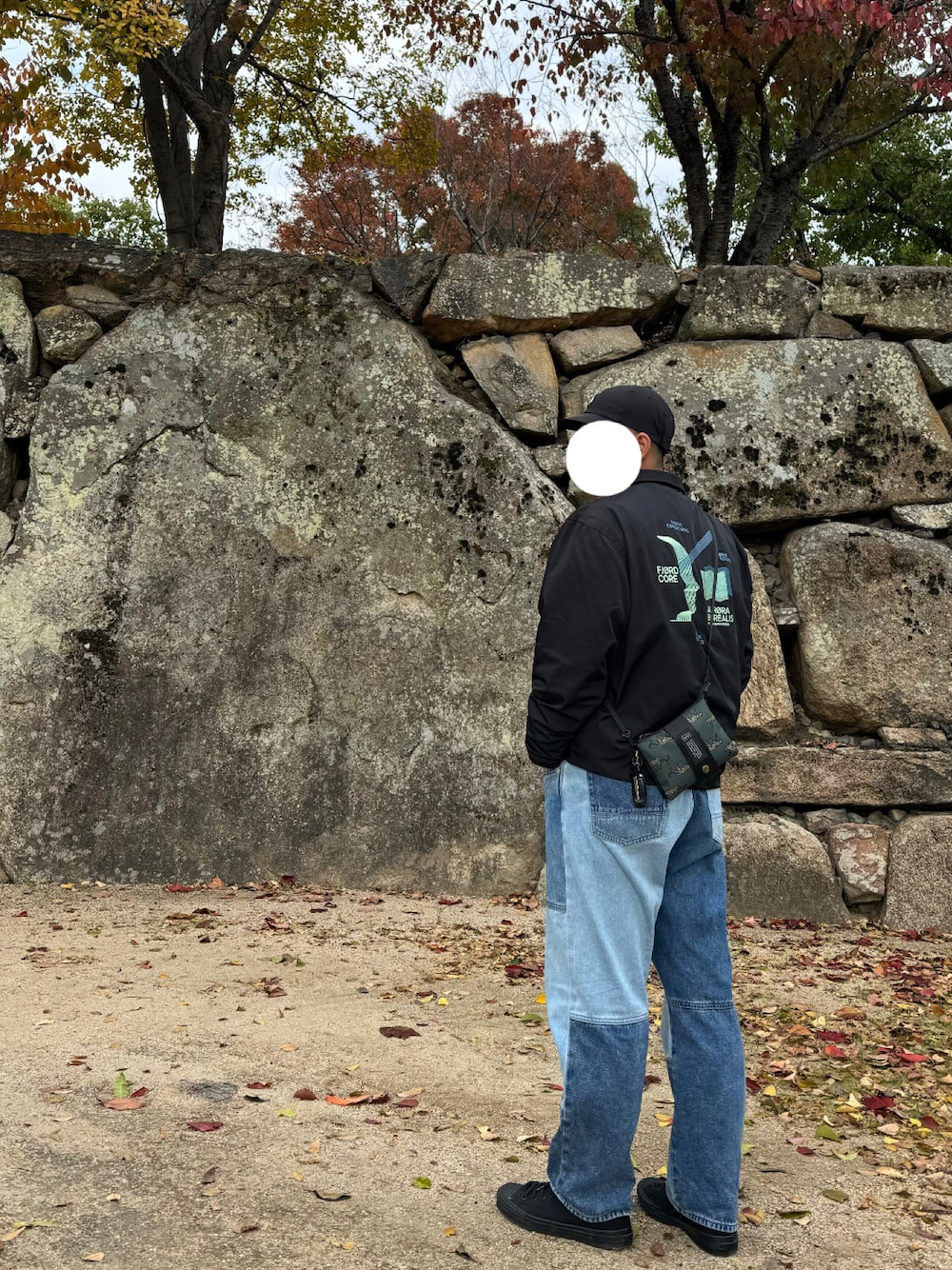 ブルー系のデニムパンツ、ブラック系のスニーカー、ブラック系のジャケット/アウターを着用したメンズの冬コーディネートの1枚目の写真