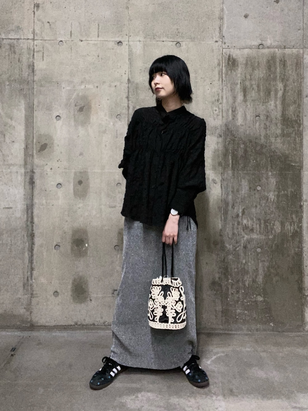 ブラック系のシャツ/ブラウス、グレー系のスカート、ブラウン系のハンドバッグを着用したレディースの夏コーディネートの1枚目の写真