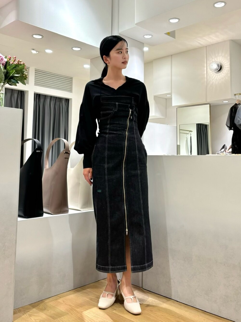 ブラック系のワンピース、ホワイト系のパンプス、ブラック系のシャツ/ブラウスを着用したレディースの春コーディネートの1枚目の写真