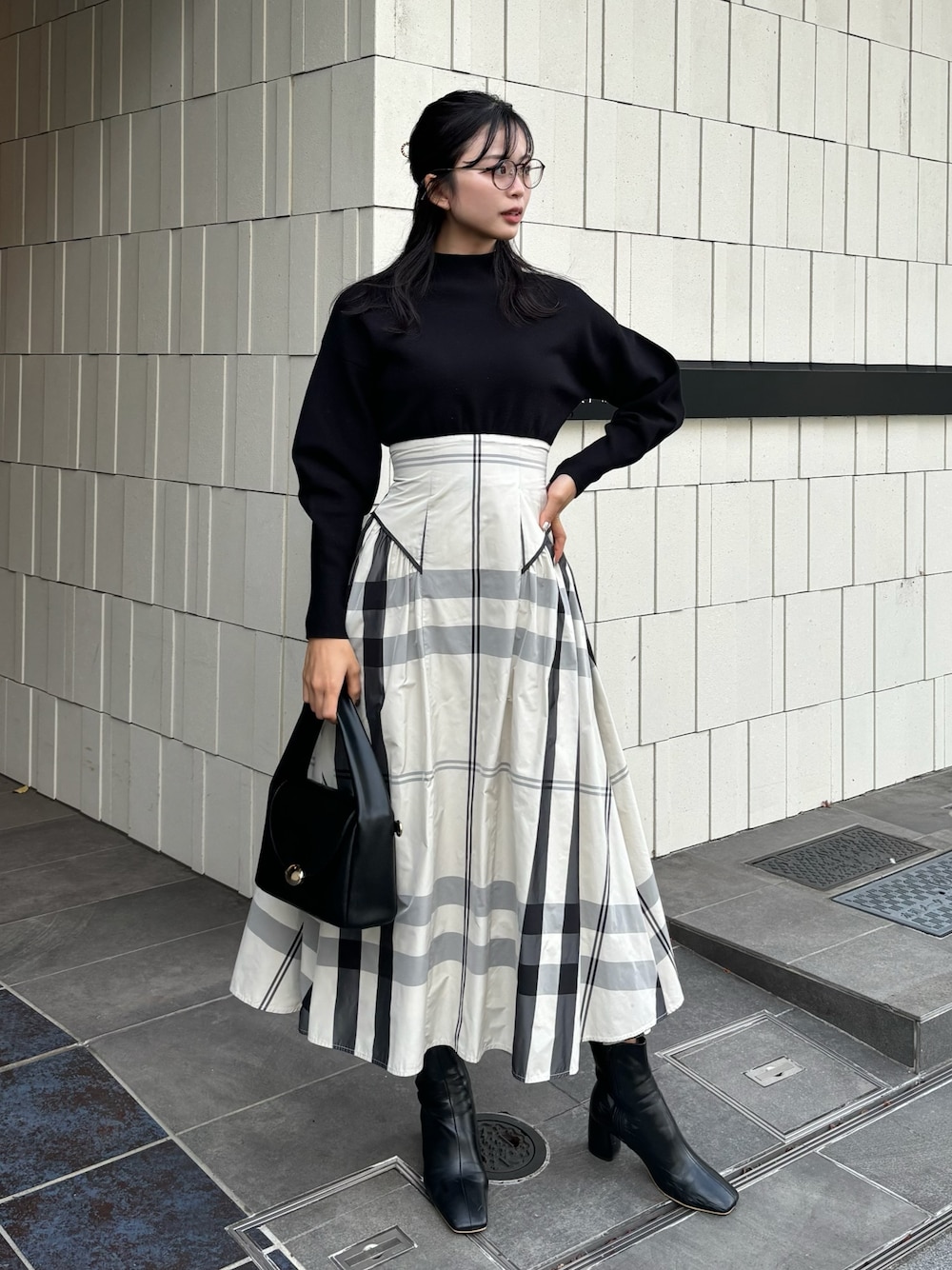 ホワイト系のワンピース、ブラック系のハンドバッグ、ブラック系のブーツを着用したレディースの冬コーディネートの1枚目の写真