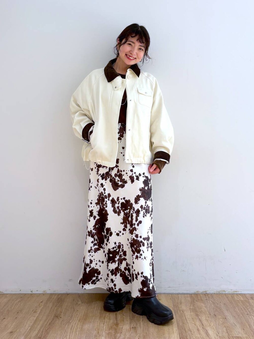 ブラック系のブーツ、その他のスカート、ブラウン系のTシャツ/カットソーを着用したレディースの秋コーディネートの1枚目の写真