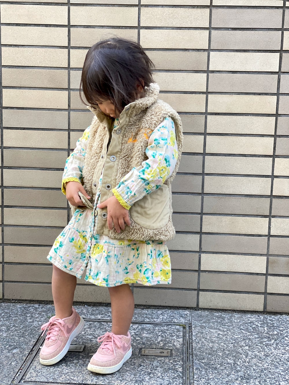 「春コーデ、キッズコーデ、花柄、花柄ワンピース、黄色、ピンク、ベスト、裸足にスニーカー、ジョジョ立ち」｜「DIESELのアイテム（ベスト、ベージュ系）」を使った、Rin&Rayさん（キッズ・100cm）の春コーディネートの1枚目の写真