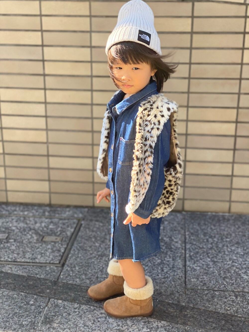 「ひょう柄、ベスト、デニムワンピース、THE NORTH FACE、キャップ、UGG、ブーツ、秋コーデ」｜「THE NORTH FACEのTHE NORTH FACE/ザ・ノース・フェイス/KIDS' CAPPUCHO LID/キッズ カプッチョリッド/HEADWEAR/ﾍｯﾄﾞｳｪｱ/NNJ41710/KIDS' CAPPUCHO LID（ニットキャップ/ビーニー、ベージュ系）」を使った、Rin&Rayさん（キッズ・100cm）の秋コーディネートの1枚目の写真