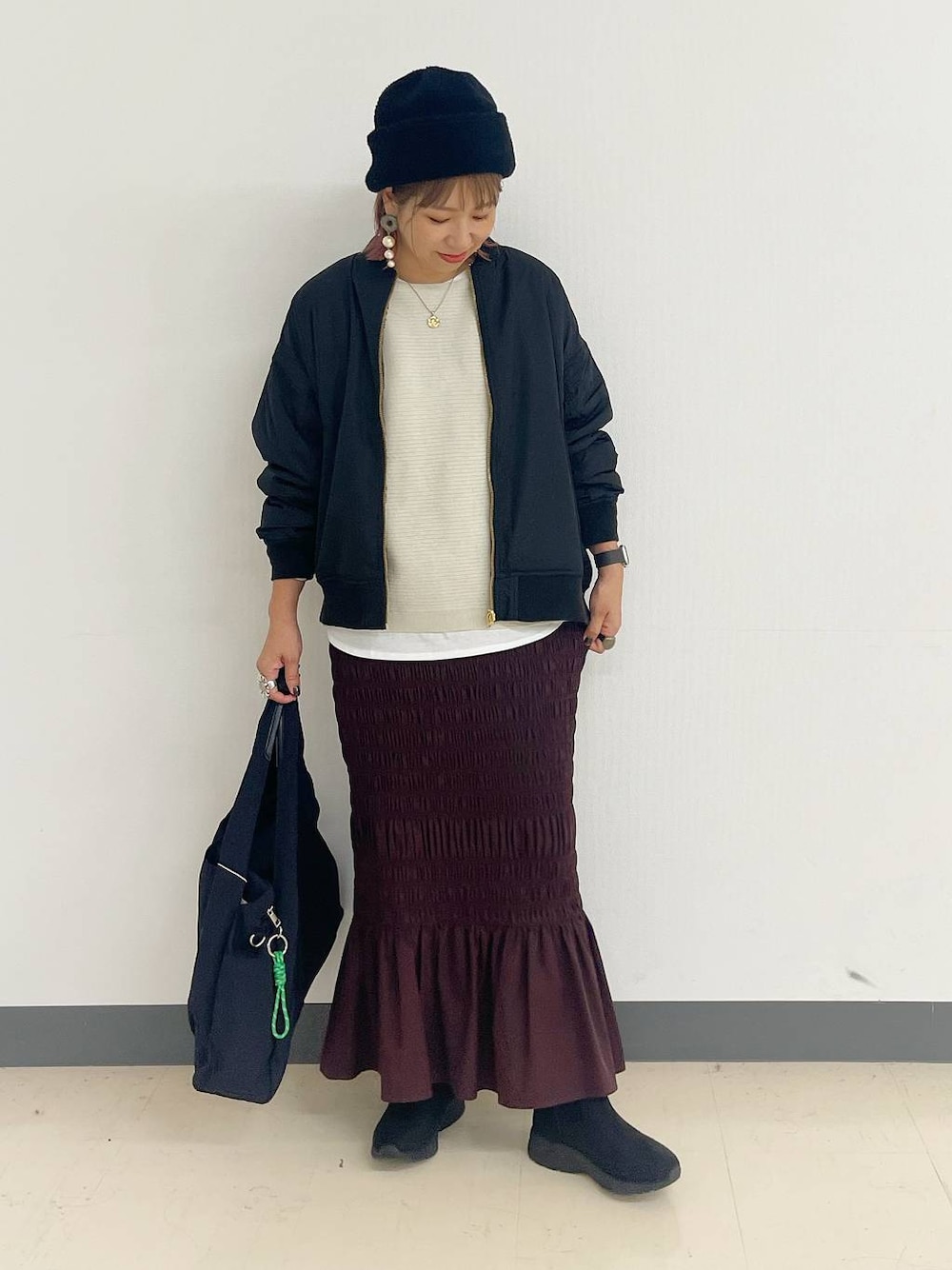 ブラック系のトートバッグ、ブラック系のブルゾン、ブラック系のブーツを着用したレディースの秋コーディネートの1枚目の写真