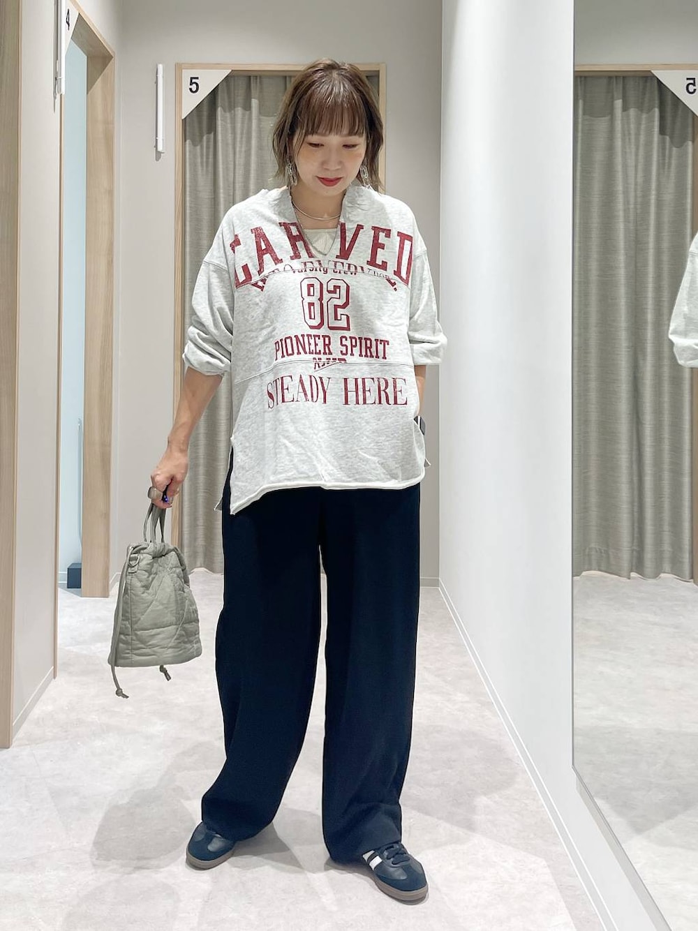 グリーン系のハンドバッグ、シルバー系のネックレス、シルバー系のネックレスを着用したレディースの秋コーディネートの1枚目の写真