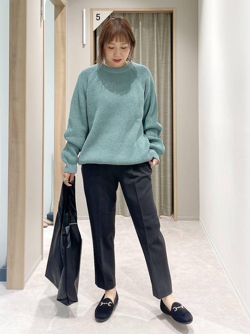 グレー系のその他パンツ、ホワイト系のTシャツ/カットソー、グリーン系のニット/セーターを着用したレディースの秋コーディネートの1枚目の写真