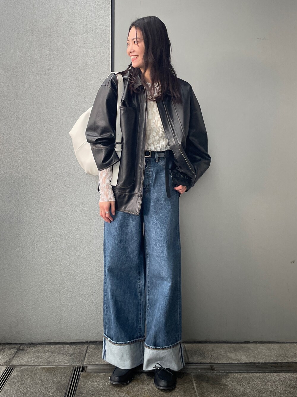 ブルー系のデニムパンツ、ブラック系のブルゾン、ブラック系のローファーを着用したレディースの冬コーディネートの1枚目の写真