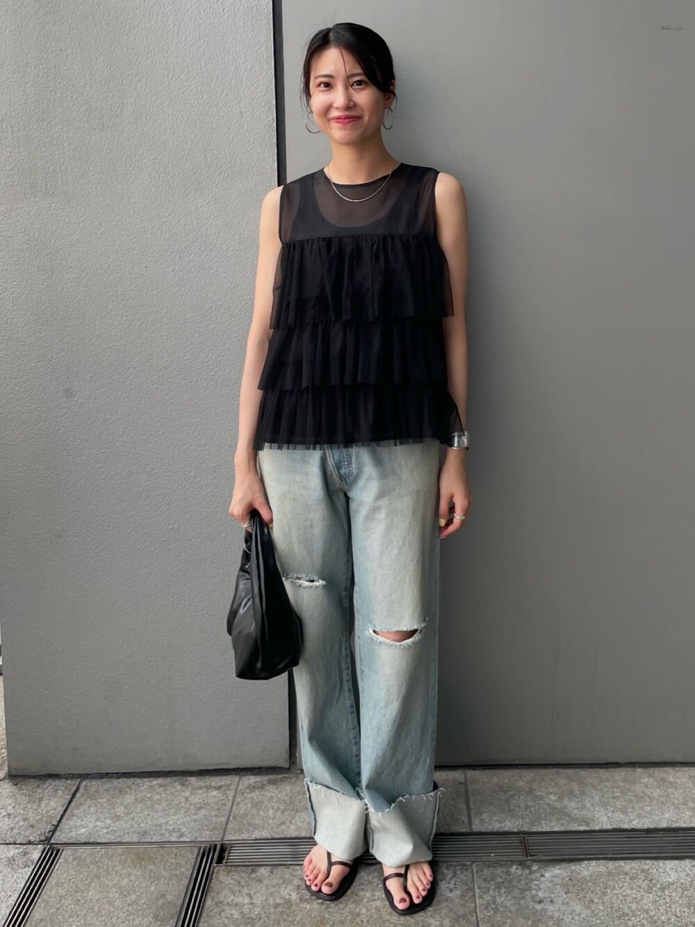 ブラック系のシャツ/ブラウス、ブルー系のデニムパンツを着用したレディースの夏コーディネートの1枚目の写真