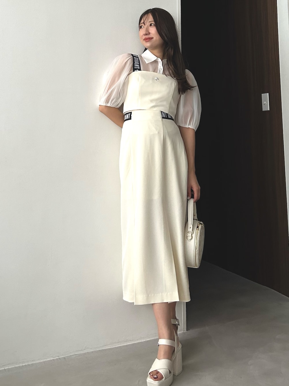 ホワイト系のシャツ/ブラウス、ホワイト系のスカート、ホワイト系のショルダーバッグを着用したレディースの冬コーディネートの1枚目の写真