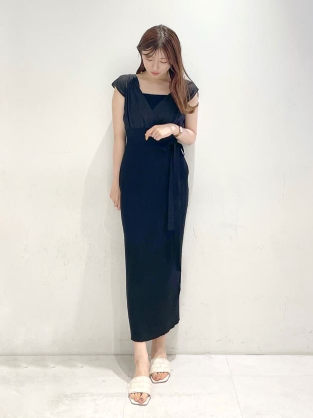 ブラック系のワンピース、ホワイト系のサンダルを着用したレディースの春コーディネートの1枚目の写真