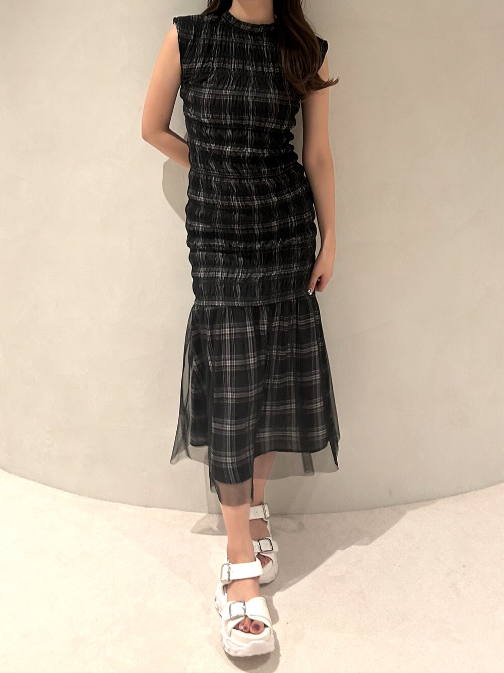 ブラック系のワンピース、ホワイト系のサンダルを着用したレディースの夏コーディネートの1枚目の写真