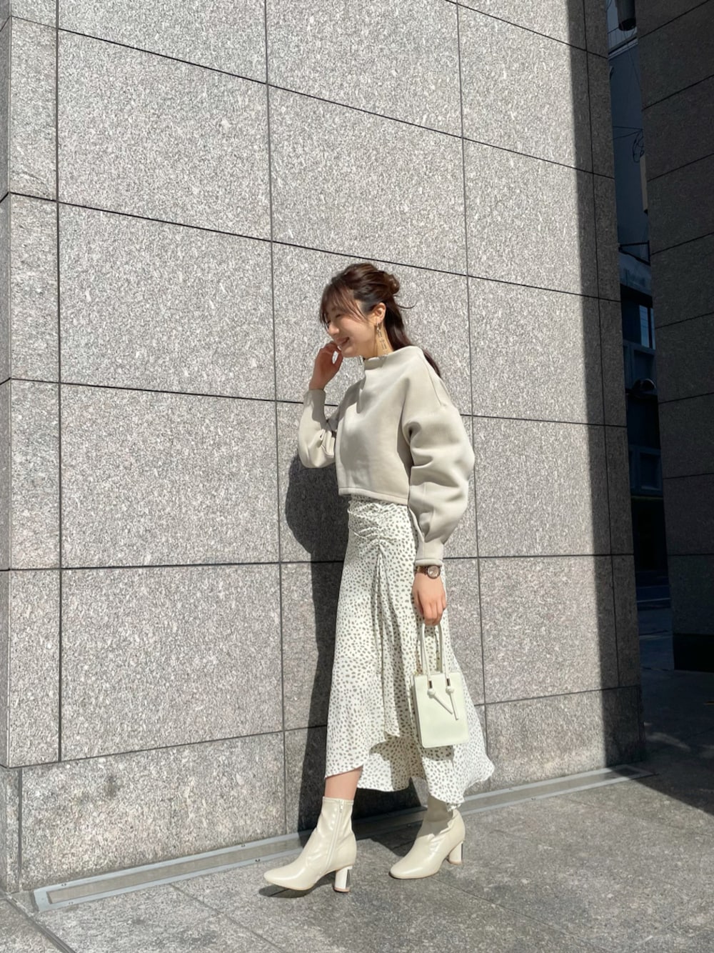 その他のスカート、ホワイト系のハンドバッグ、ホワイト系のブーツを着用したレディースの冬コーディネートの1枚目の写真