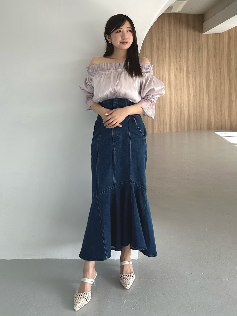 パープル系のシャツ/ブラウス、ブルー系のデニムスカート、ホワイト系のパンプスを着用したレディースの春コーディネートの1枚目の写真