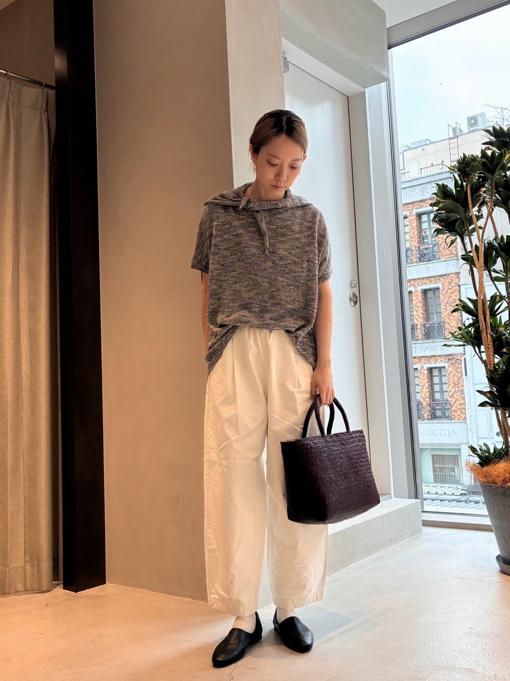 ブラック系のニット/セーター、ホワイト系のその他パンツ、ブラウン系のトートバッグを着用したレディースの夏コーディネートの1枚目の写真
