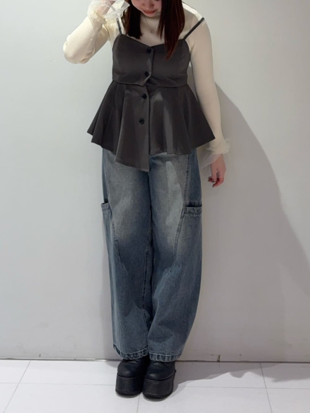 ブラック系のブーツ、グレー系のその他トップス、ブルー系のデニムパンツを着用したレディースの春コーディネートの1枚目の写真