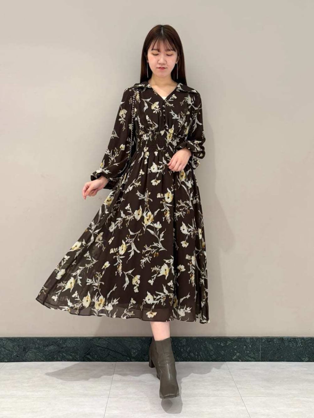 ベージュ系のキャミソール、ブラック系のショルダーバッグ、ブラウン系のワンピースを着用したレディースの冬コーディネートの1枚目の写真